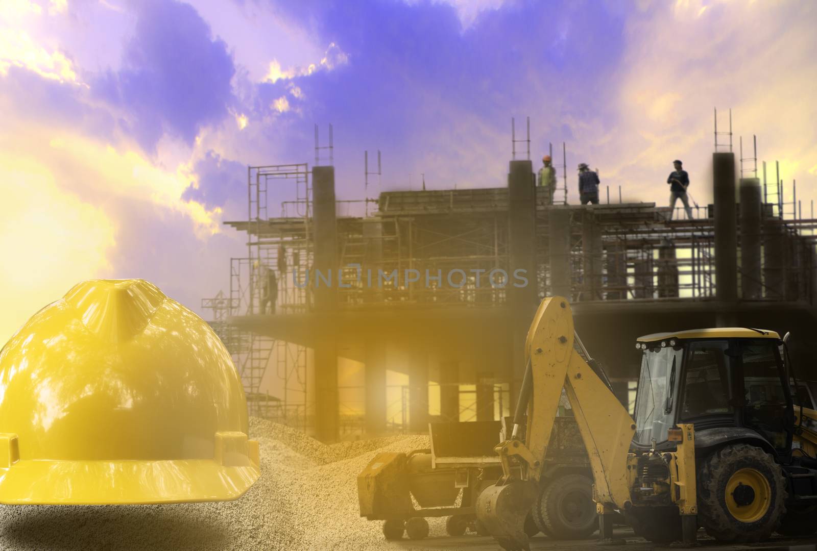 Construction industry building on high ground with yellow helmet and backhoe