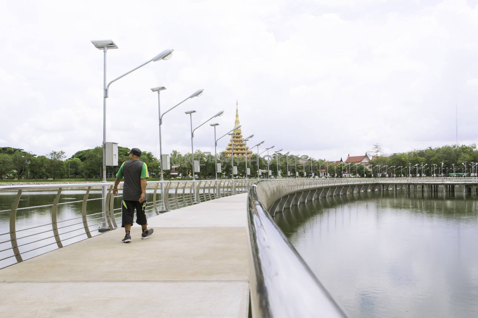 Man walking on the bridge street walkway.