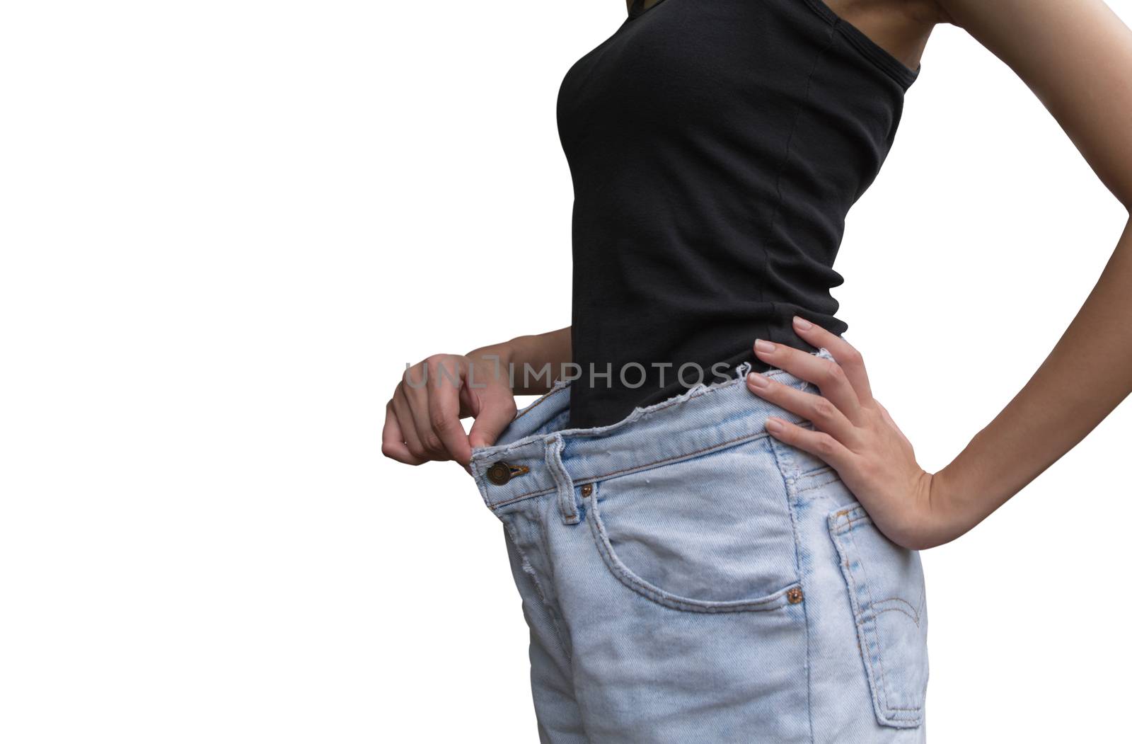 Young slim woman in oversize pair of blue jeans over white background.