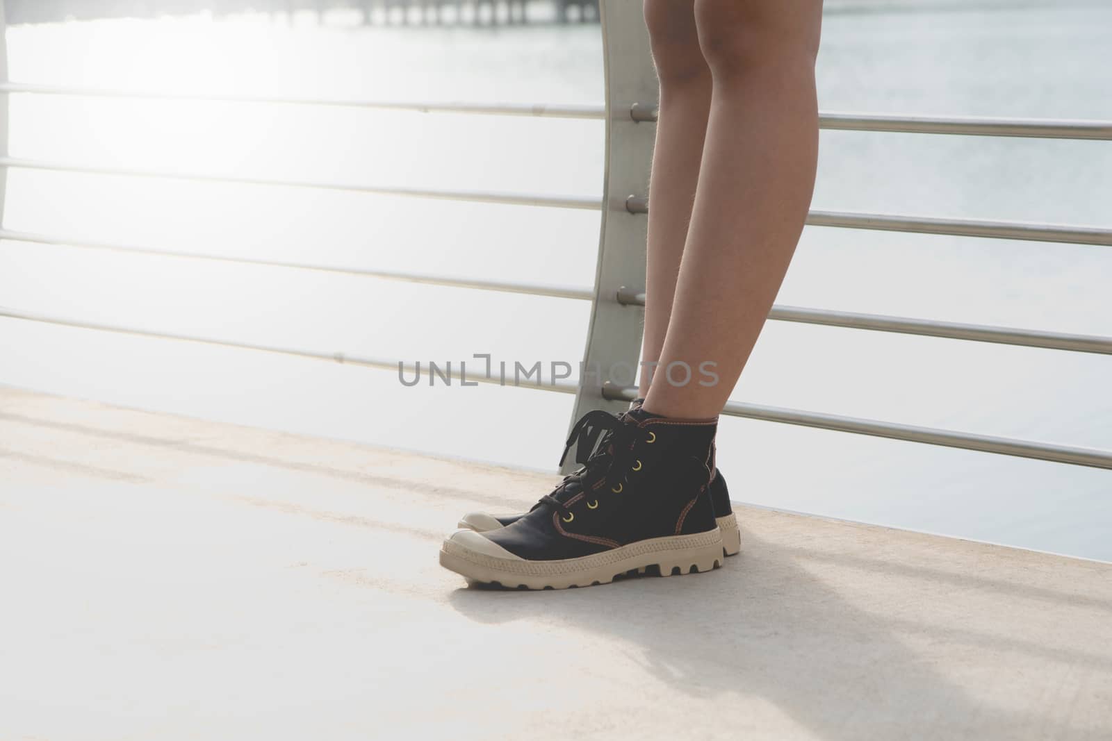A young woman is standing. Standing women sneaker shoes.