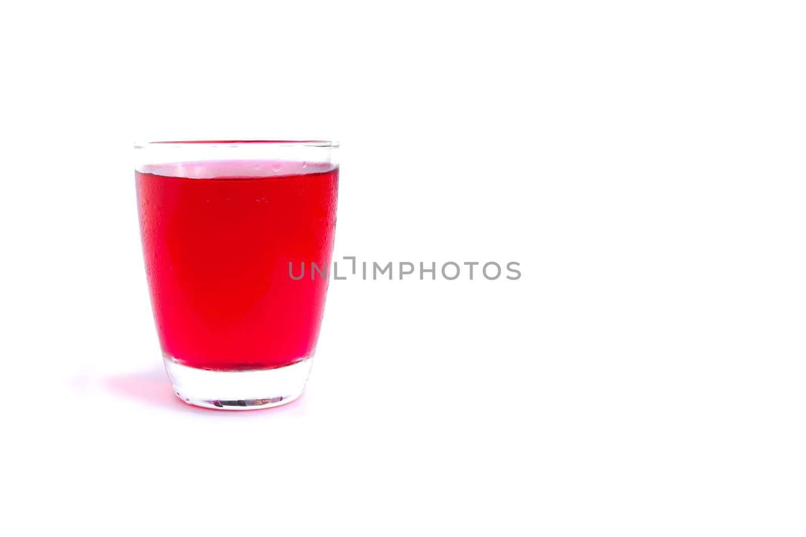 Red syrup water in glass isolated on white background.