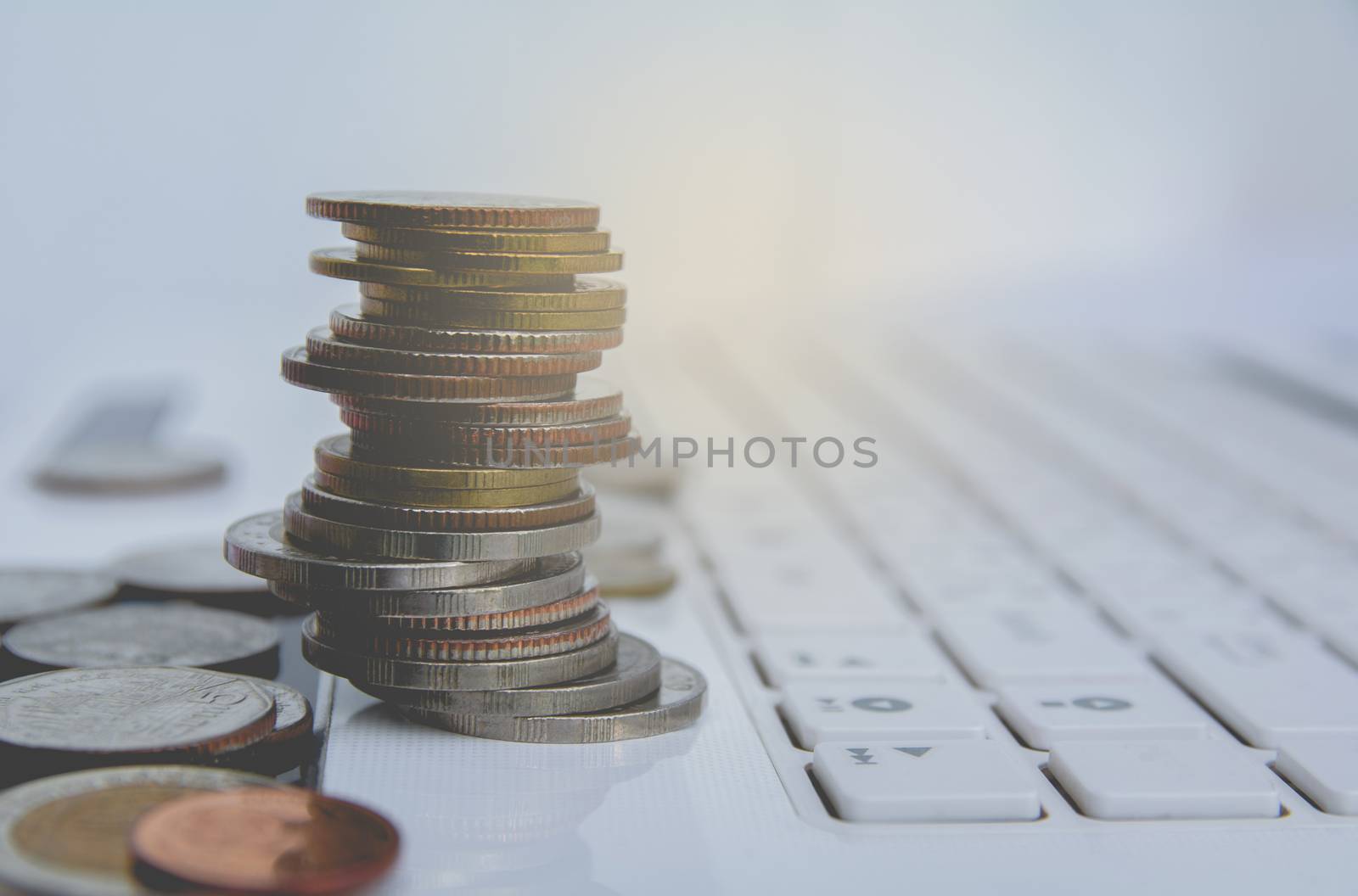 stack coins on white laptop, computer. Financial and saving conc by kirisa99