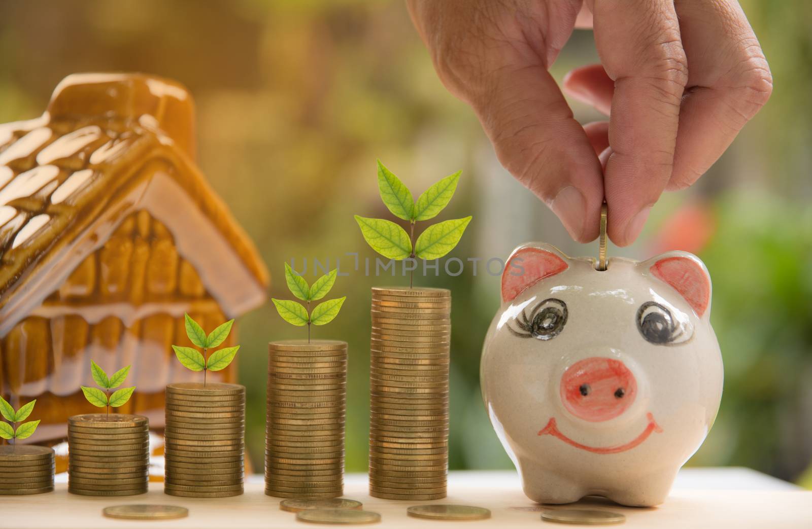 Saving money concept and hand putting money coin into piggy bank by kirisa99