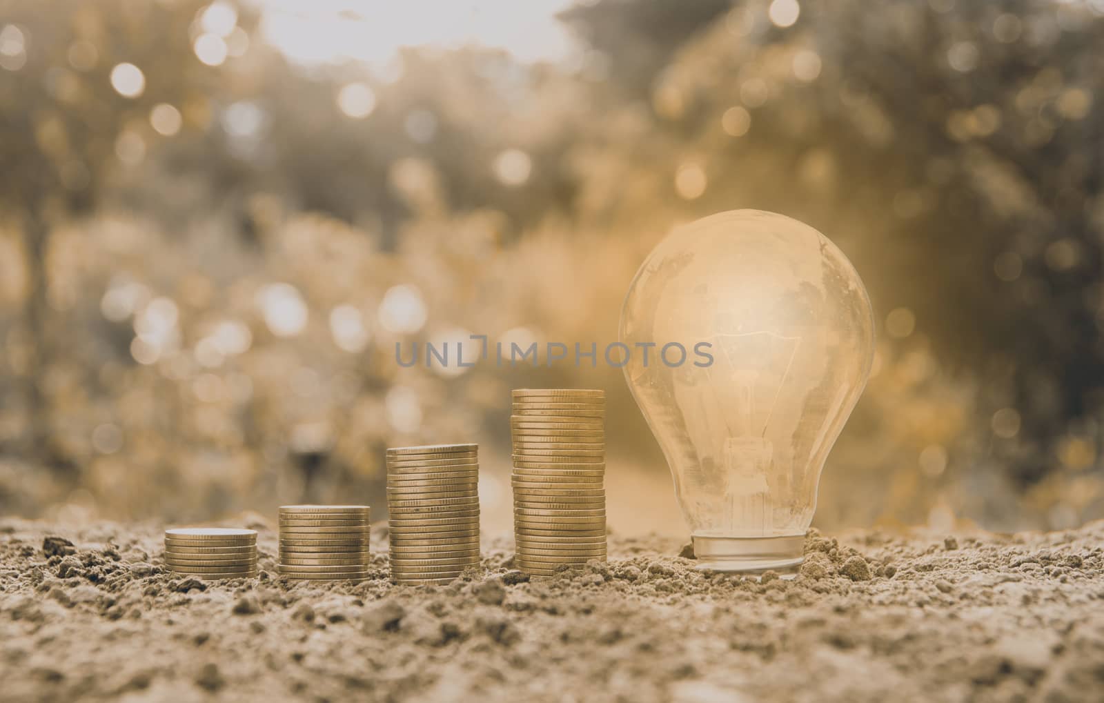 Energy saving light bulb and tree growing on stacks of coins on  by kirisa99