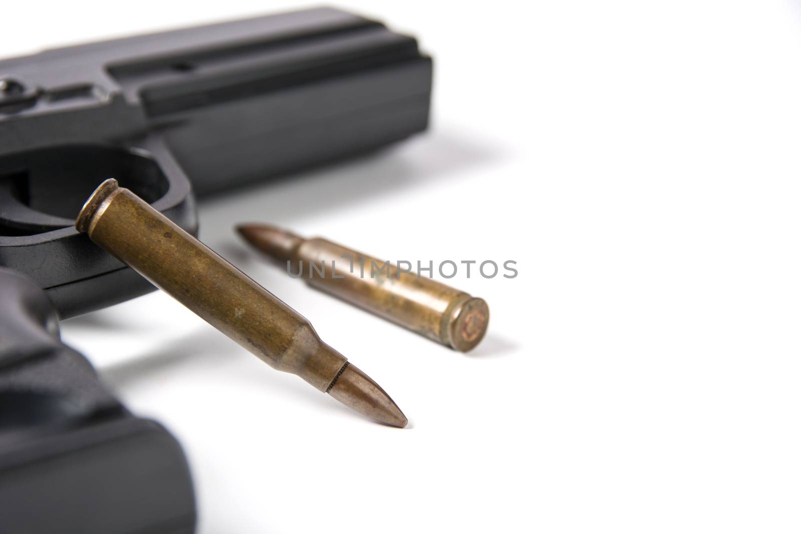 Hand gun sitting with m-16 bullets isolated on white background.