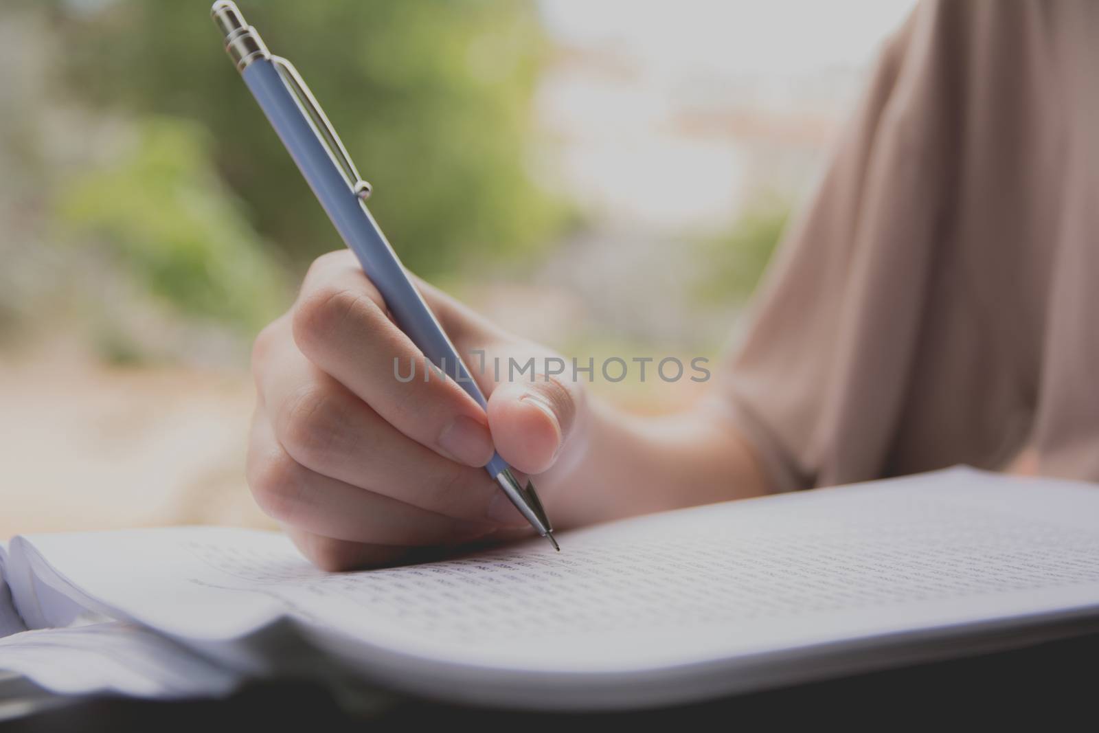 Woman sitting and holding a blue pencil and doing an exam by kirisa99