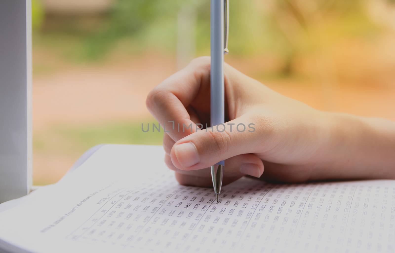 Woman sitting and holding a blue pencil and doing an exam by kirisa99