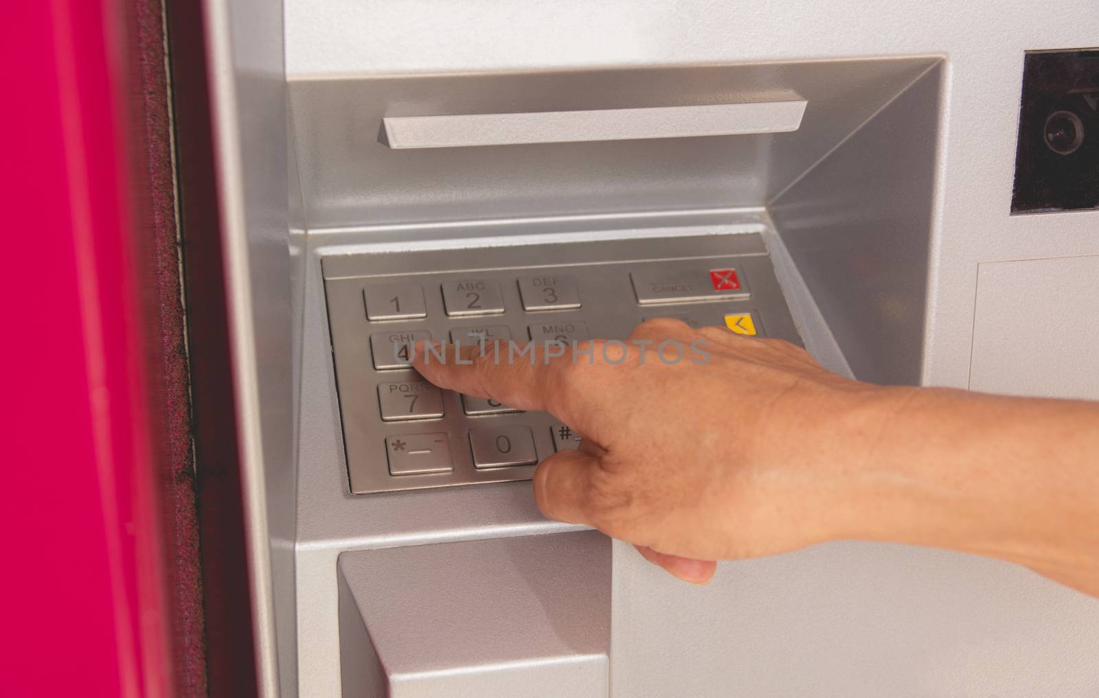 Hand of a woman push button in ATM, using an ATM. Woman using an ATM machine.