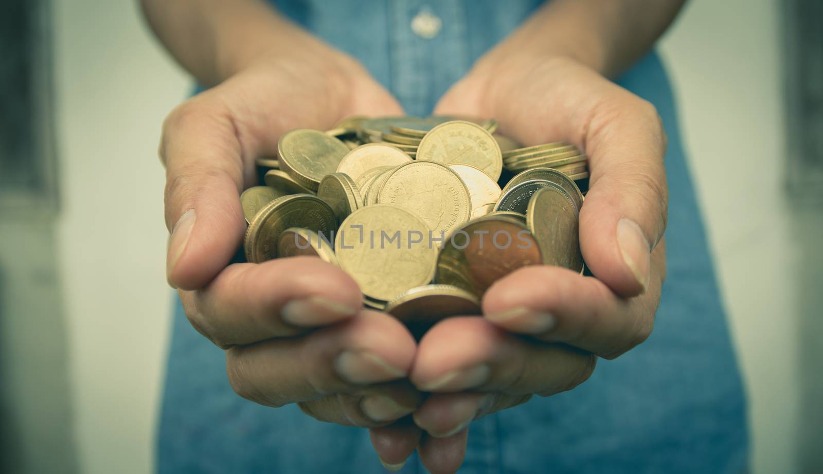 Male holding money gold coins in his hand for financial and saving money concept.