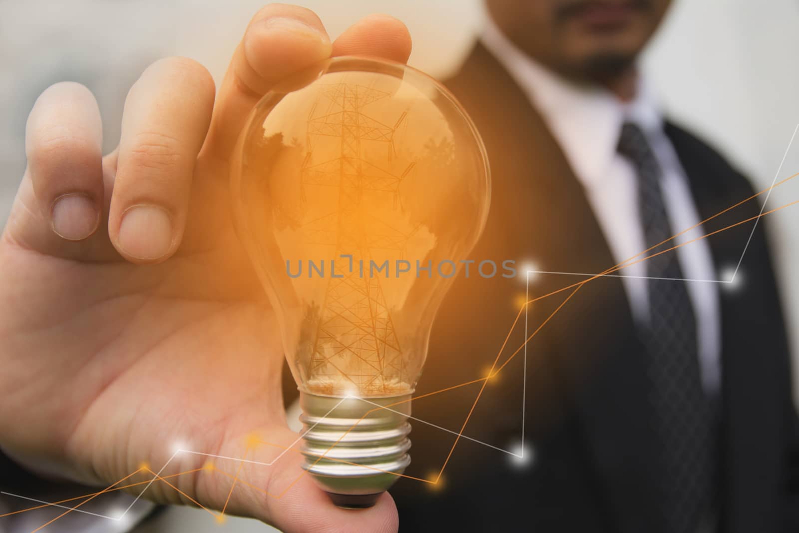 Double exposure close up of businessman hands holding glass light bulb with stock financial.