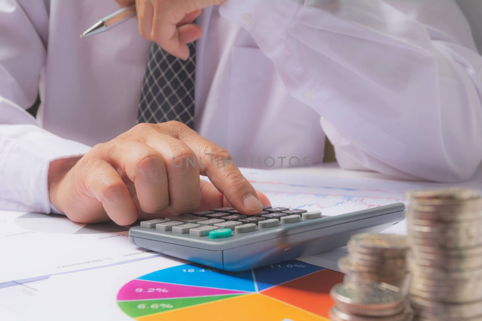 Businessman process with stack coins. Businessman working and using calculator the project on table.