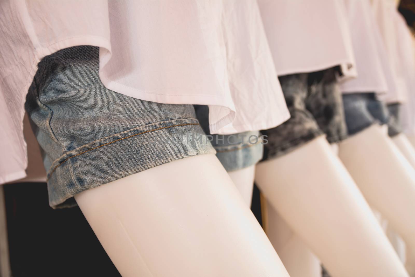 collection of jeans shorts. Modern torn blue jeans shorts on mannequin model.