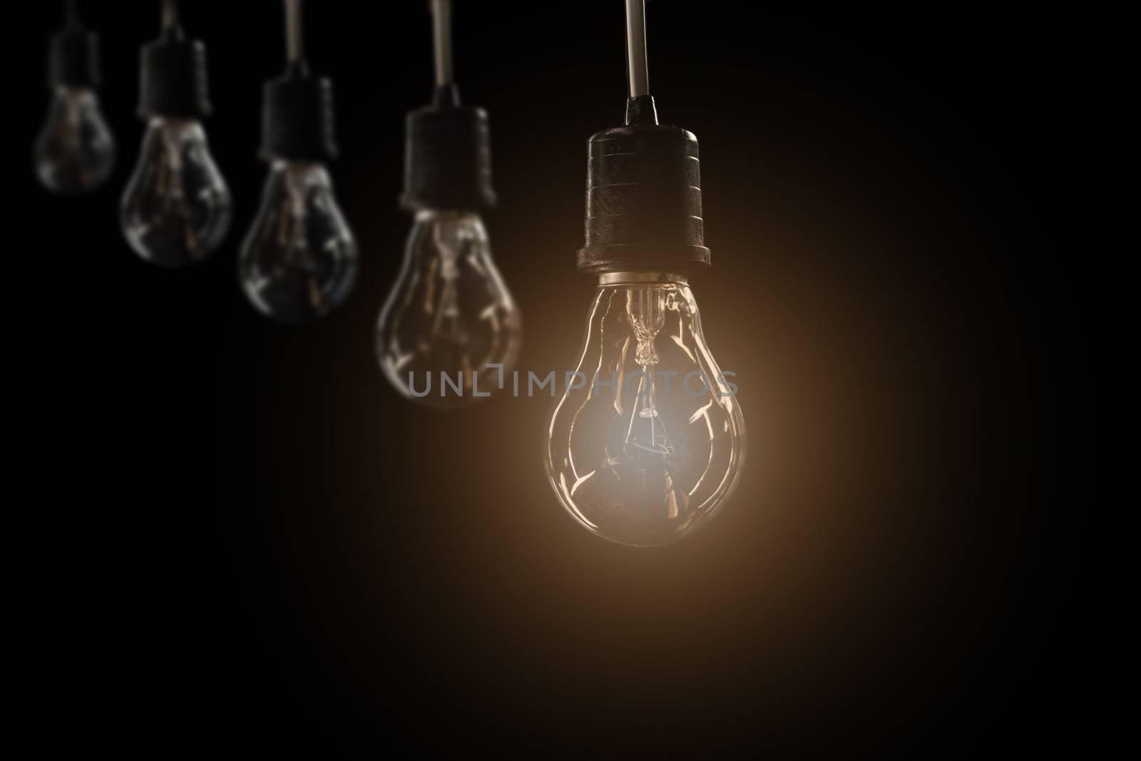 Hanging light bulbs with glowing one on dark background. Idea and creativity concept with light bulbs.