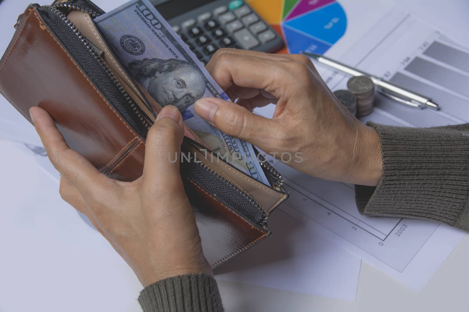 Businessman holding banknote in wallet in his hand for financial and saving money concept.