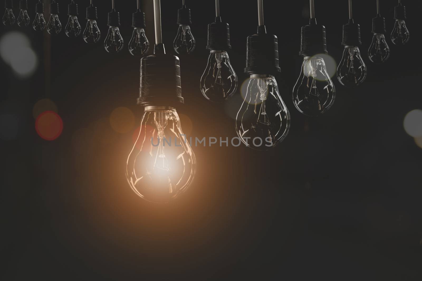 Hanging light bulbs with glowing one on dark background. Idea an by kirisa99