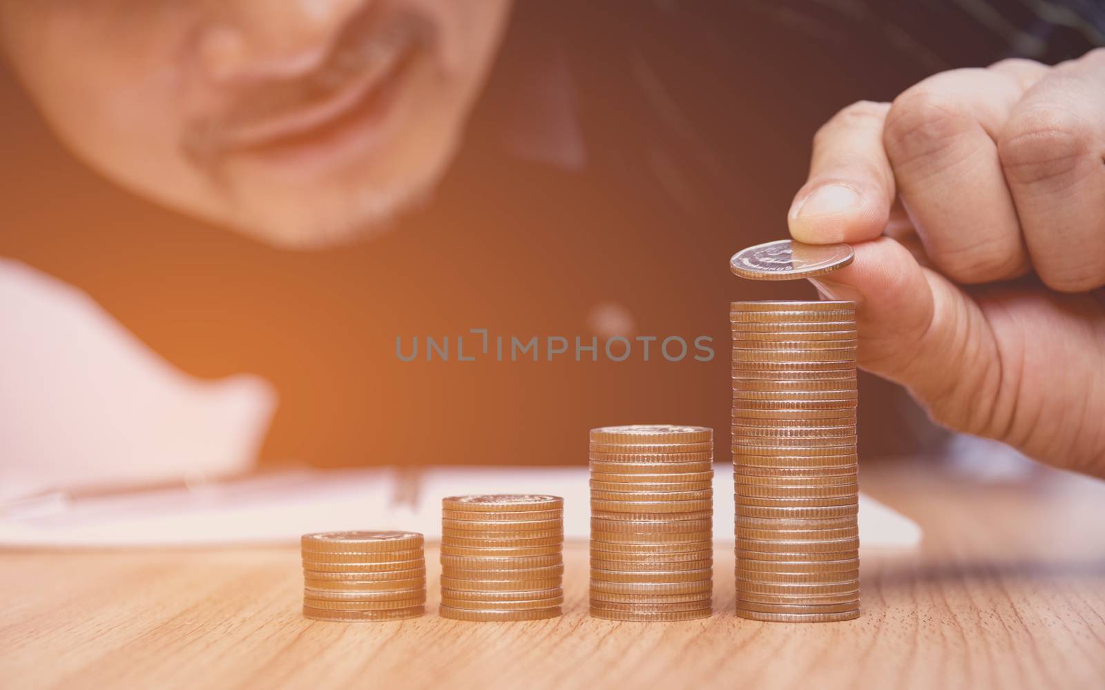 Saving money concept and hand putting money coin stack growing for business