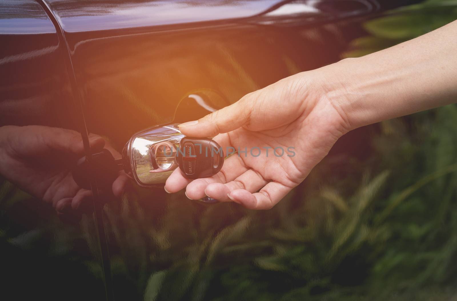 Close-up of woman opening a car door. Hand on handle. Female is opening a car.