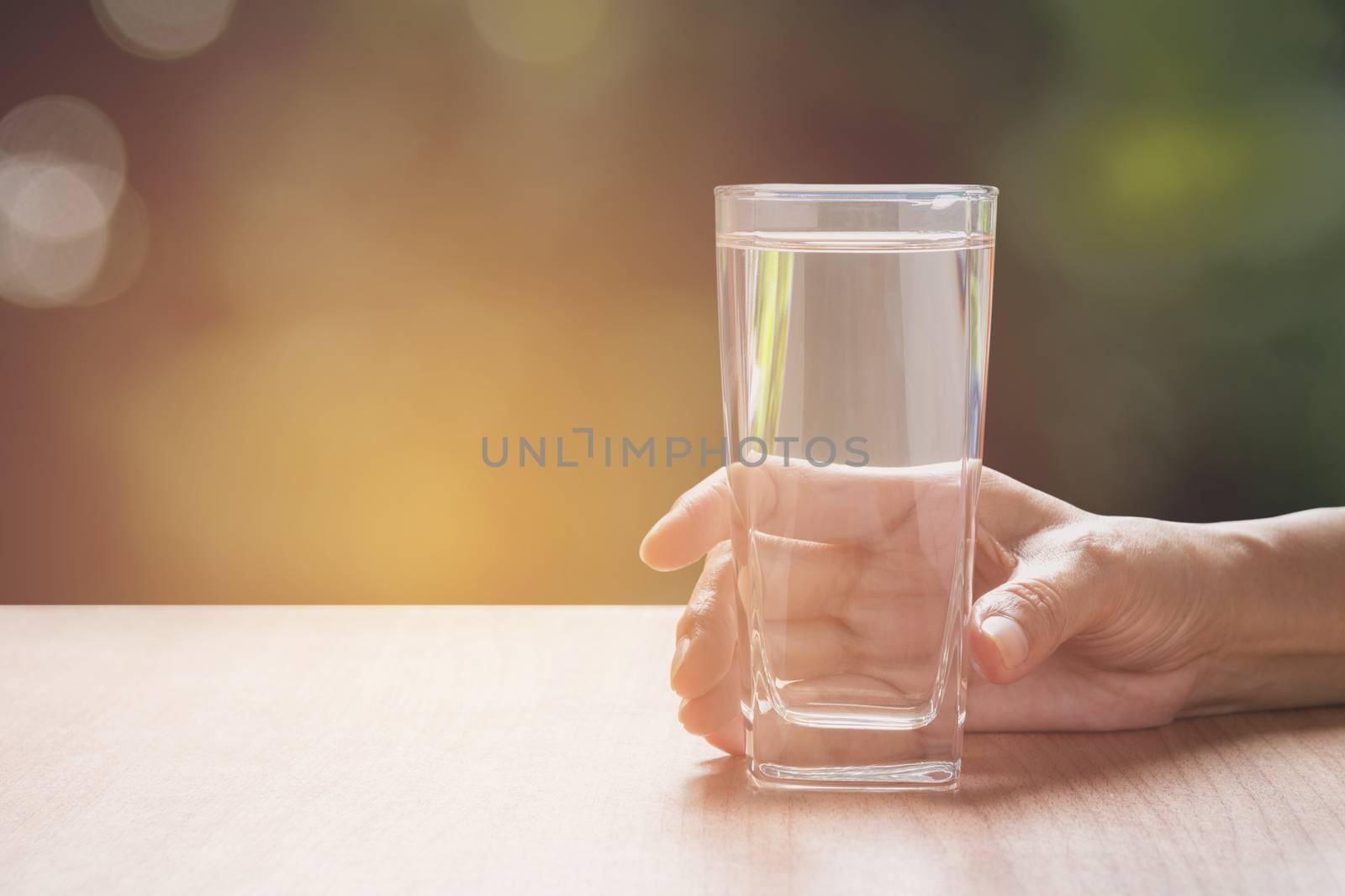 hand holding a glass of pure water. Hand holding a glass of wate by kirisa99