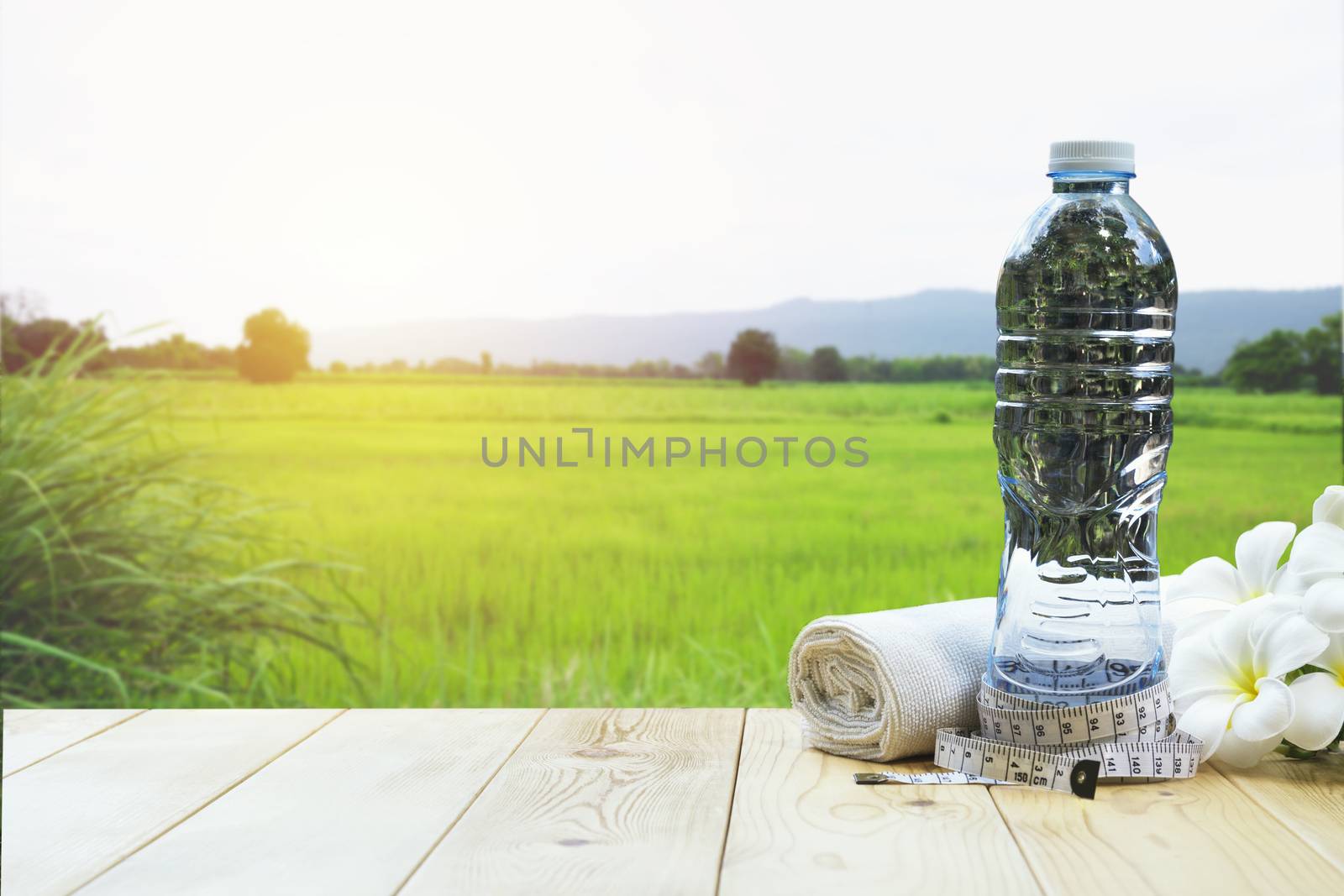 bottle of water on a wooden table with white flower and handkerc by kirisa99