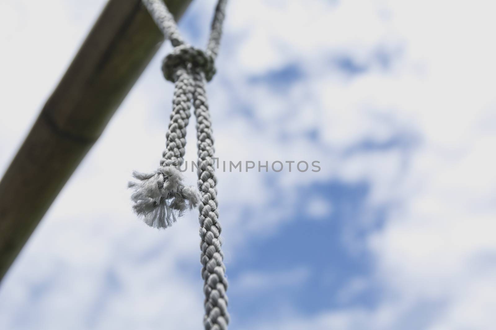 rope knot tied with old rusty steel rod under the sky.