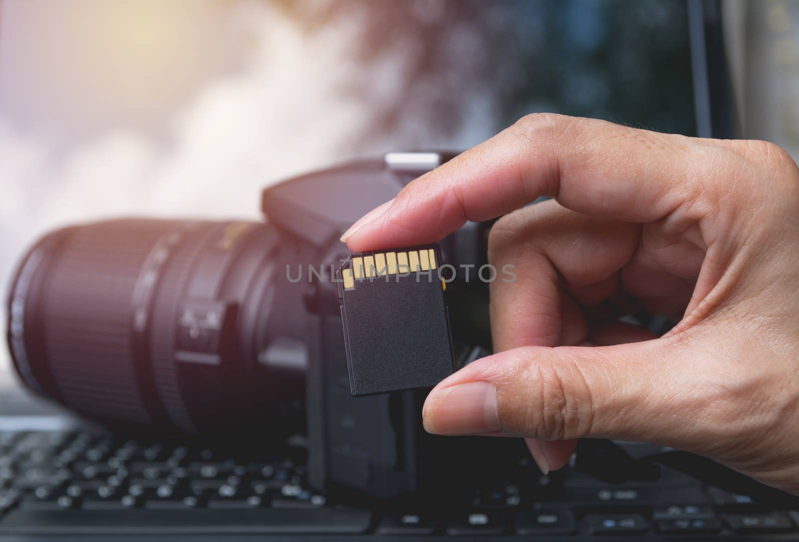 Photographer's hand holding memory card for preparing his camera by kirisa99