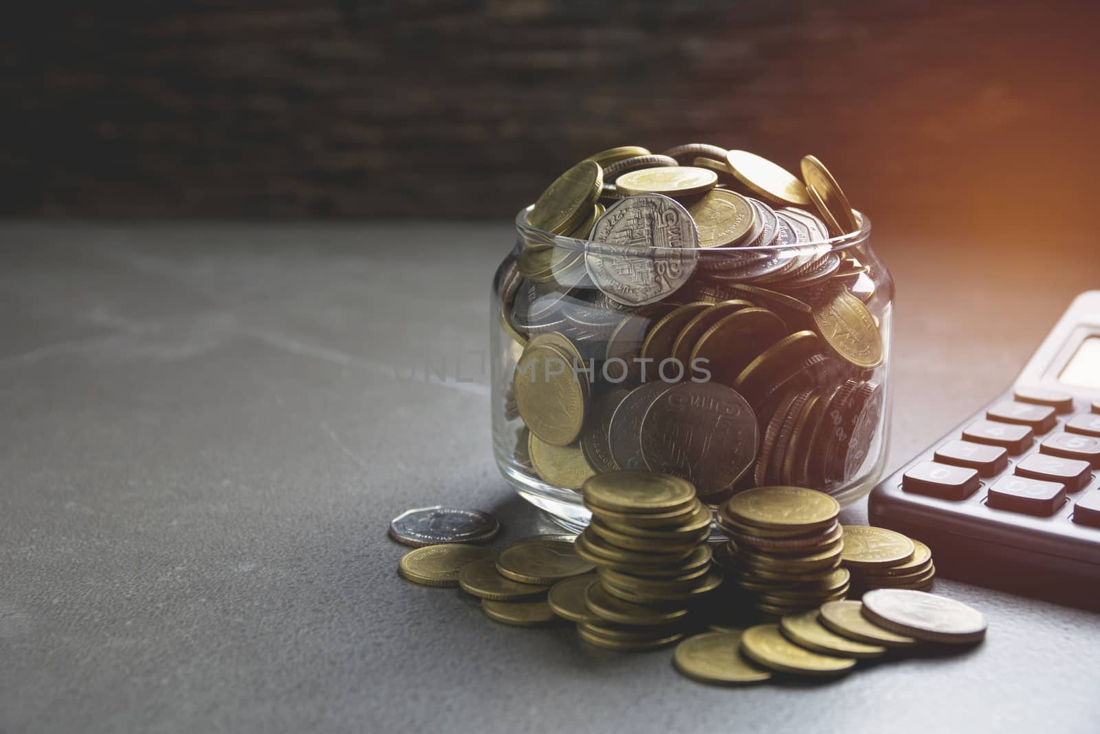 stack coin with black calculator and another coin. Financial and saving concept.