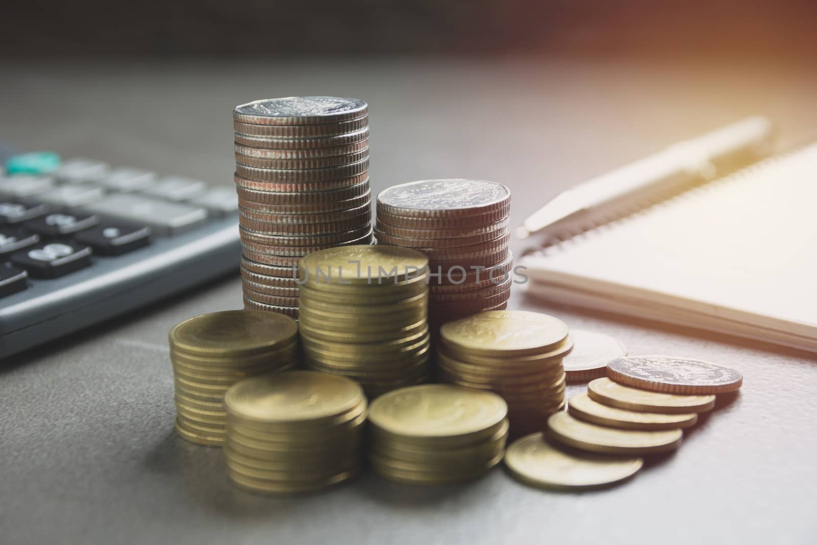 stack coin with black calculator and another coin. Financial and saving concept.