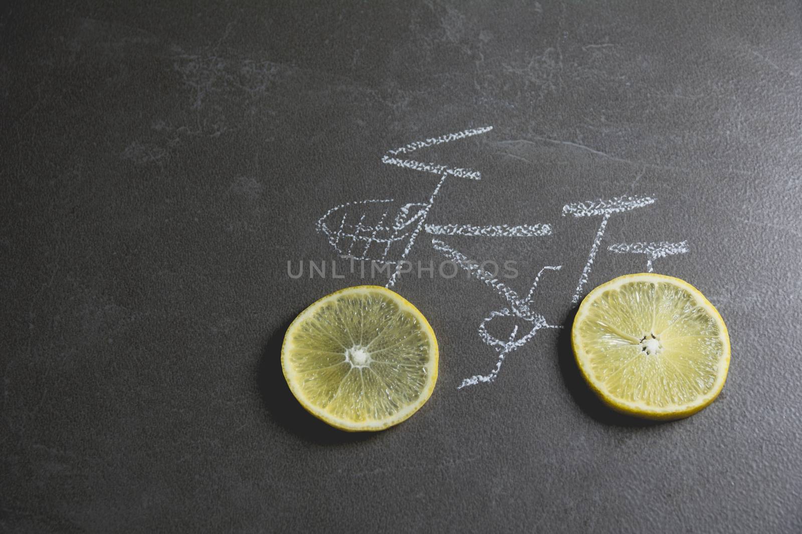 lemon slice shape wheel of bicycle paint by chalk on black table background.