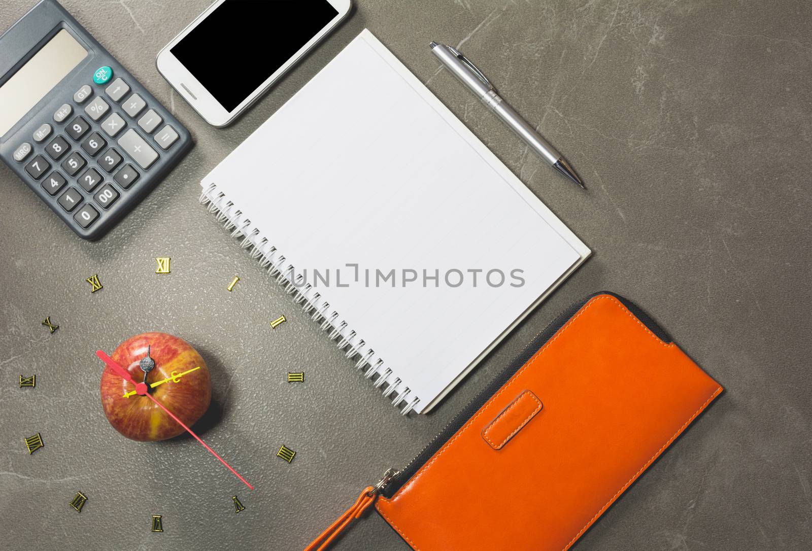 The apple with number of clock and smart phone, apple shape clock on table background. 