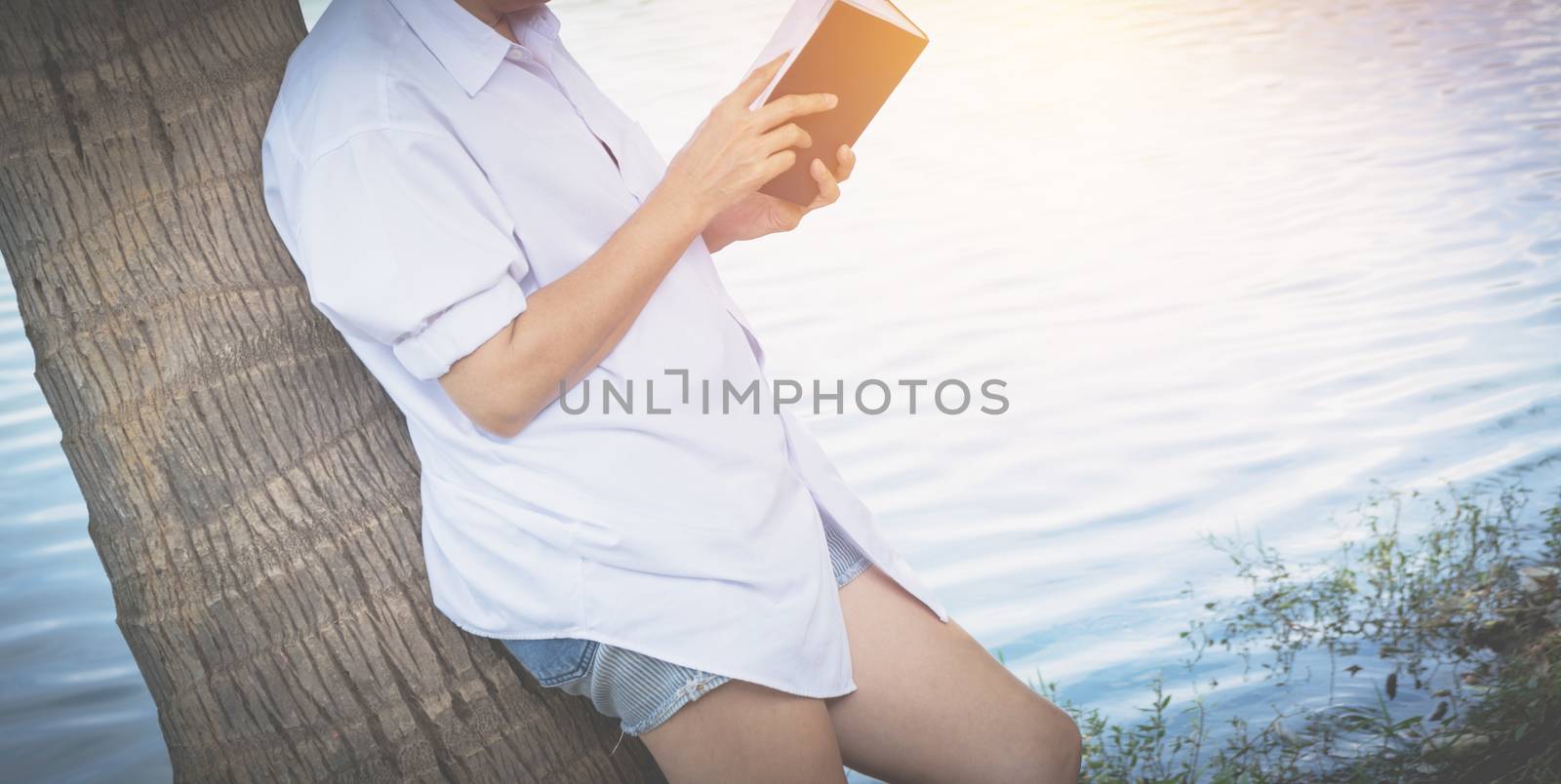 woman reading a book enjoys of rest. Woman hand holding a book for read. Concepts of rest and comfort.