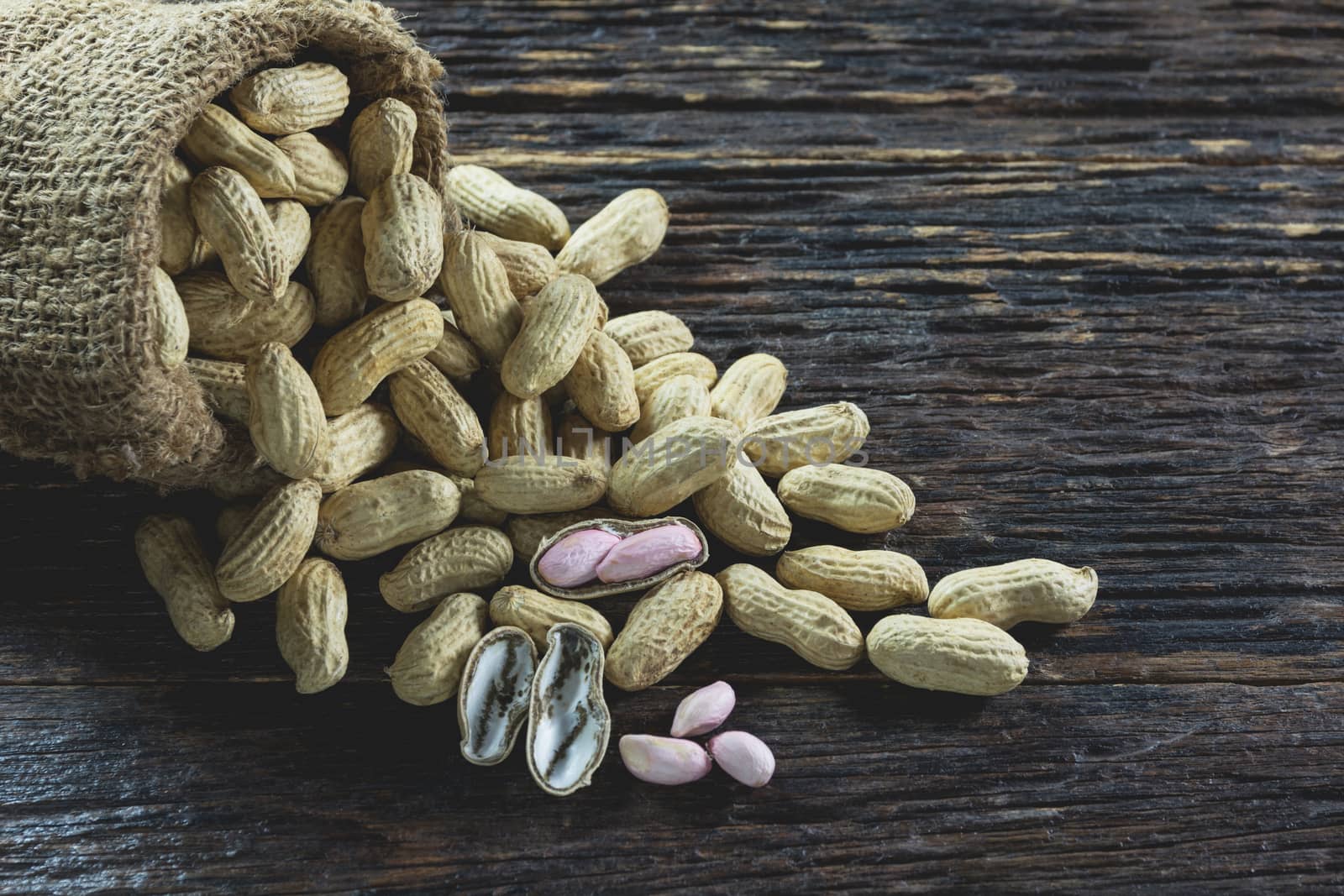 Peanuts in sack on wooden table background. peanut in shell.