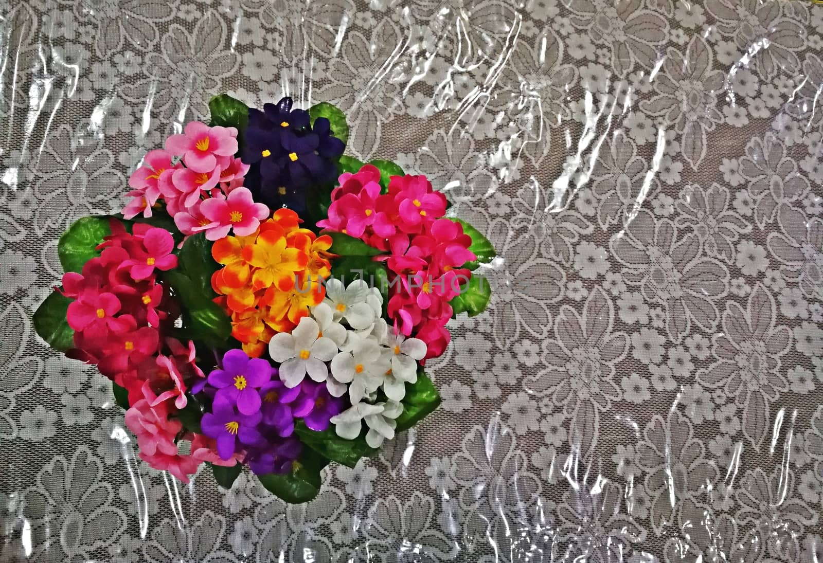 multi color of plastic flowers for decorations on office table by shatchaya