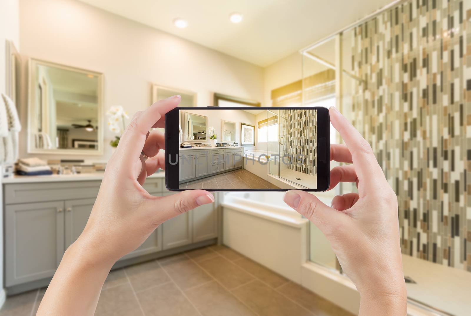 Master Bathroom Interior and Hands Holding Smart Phone with Photo on Screen.