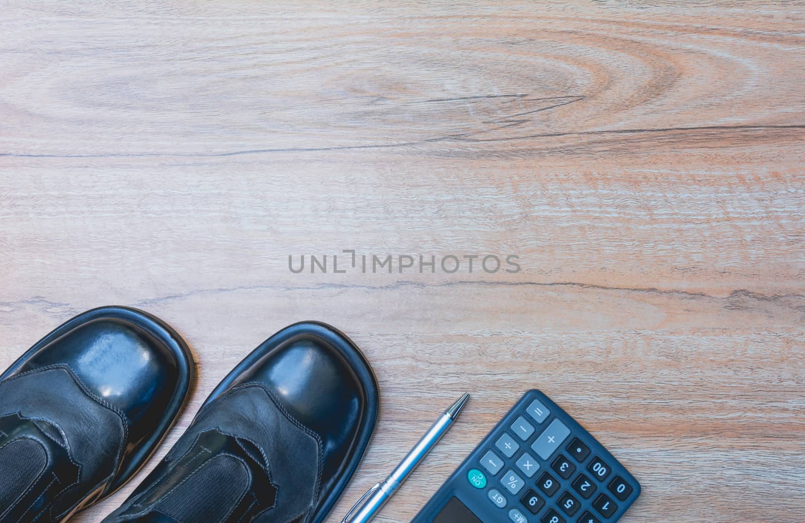 Office table with pen, calculator and shoes. View from above with copy space.