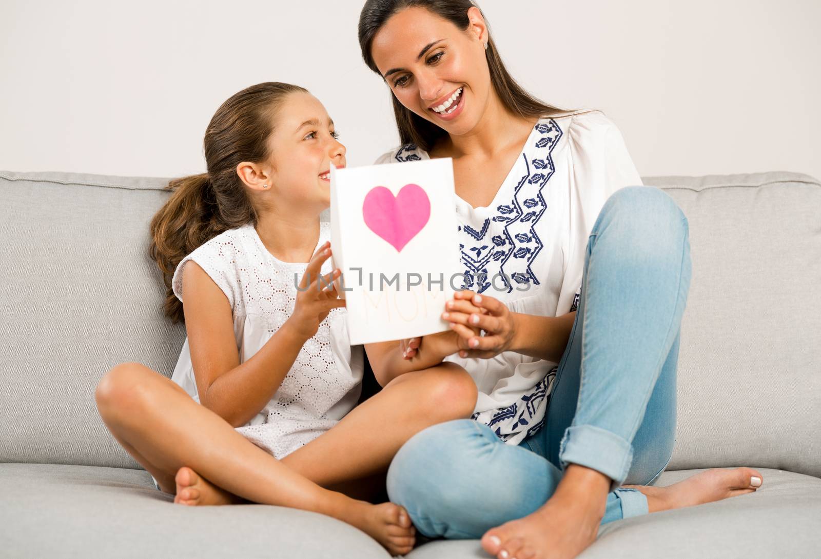 Mother receiving a greeting card on mother's day from her daughter