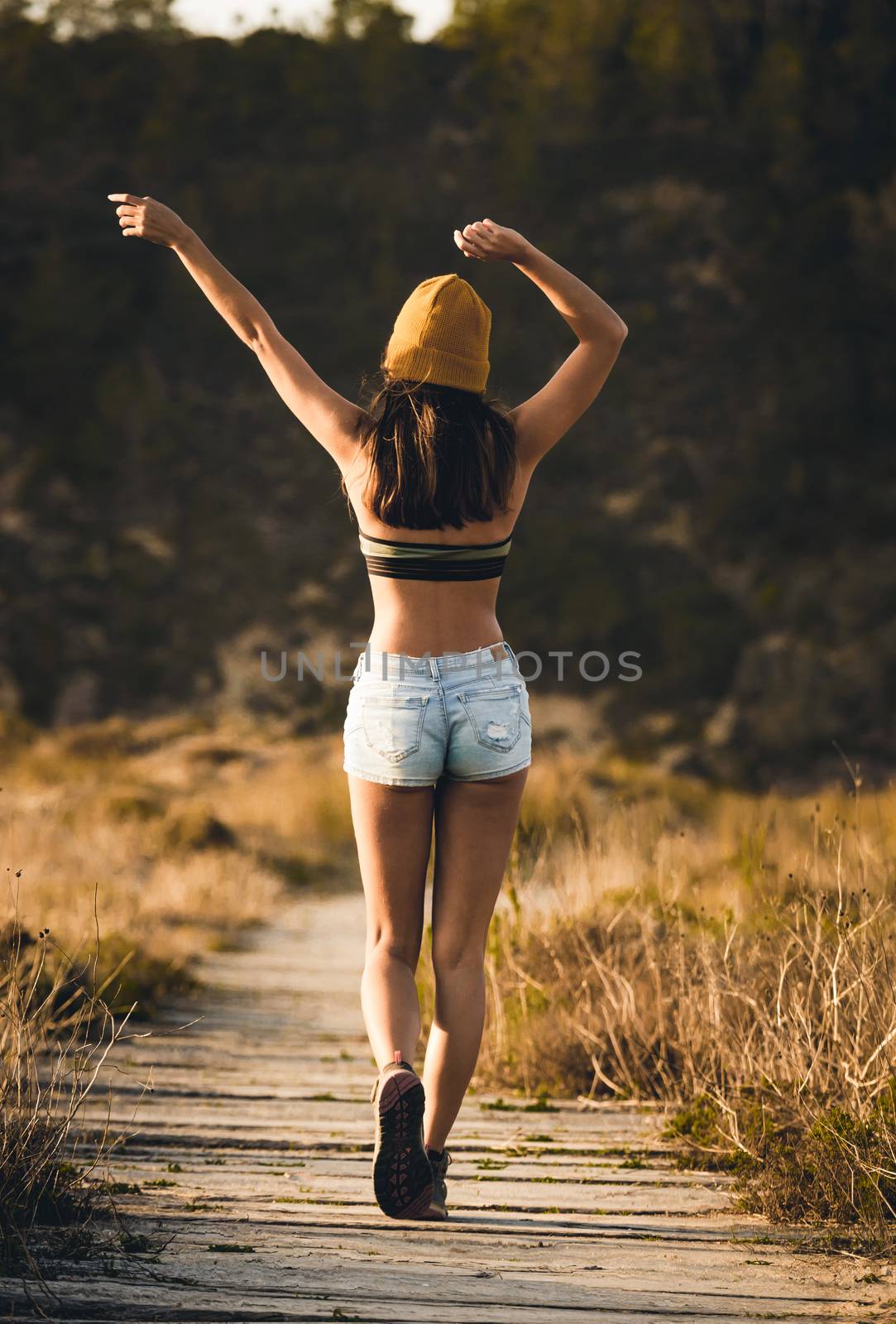 Beautiful young woman walking over a wood path