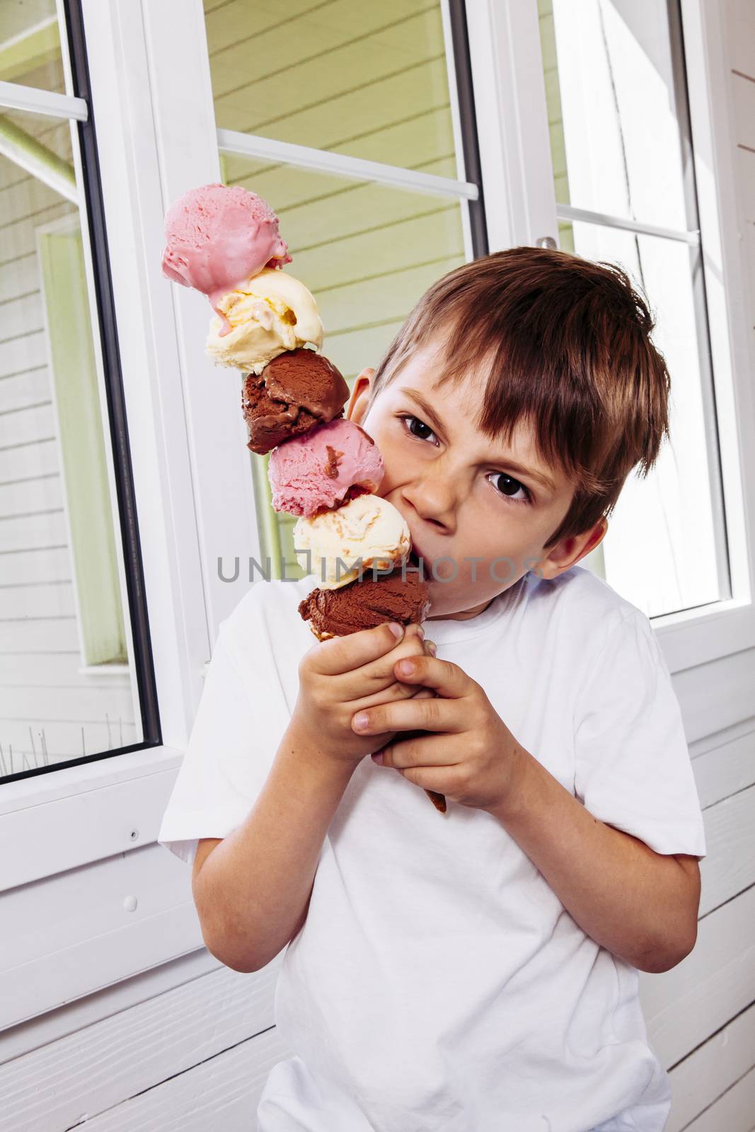 Boy eating a tall ice cream cone by sumners