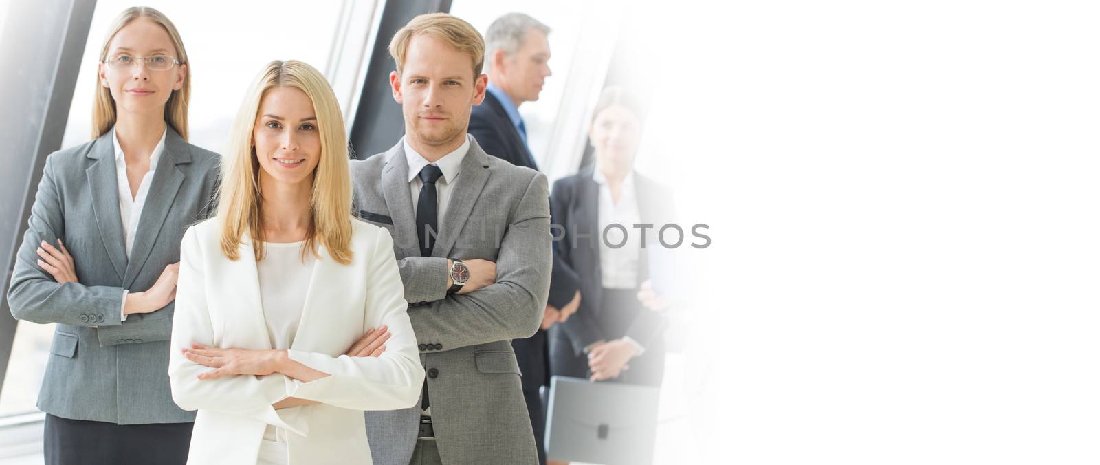 Successful business team with arms crossed at the office, white copy space