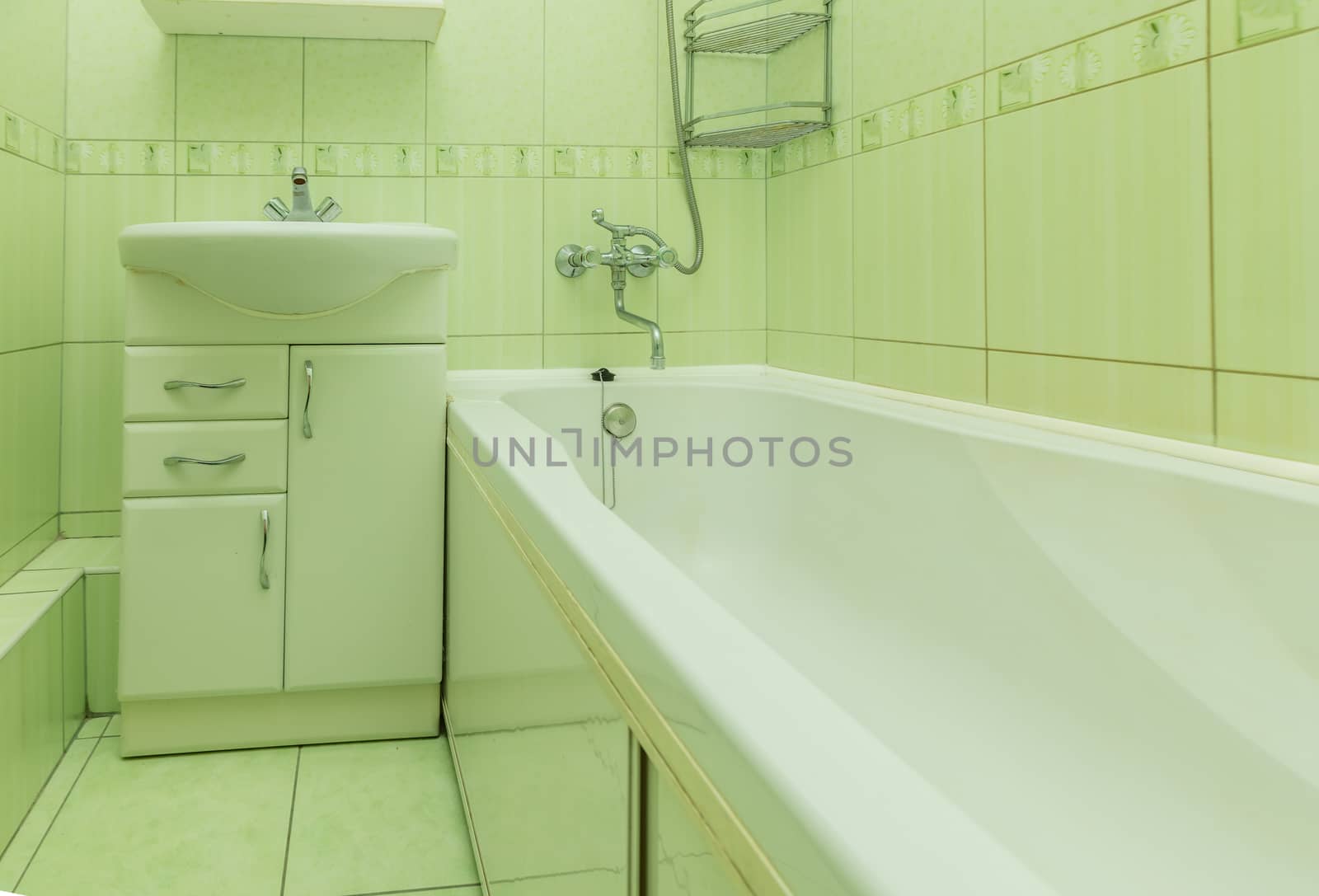 Small green tile bathroom with bath tube and sink