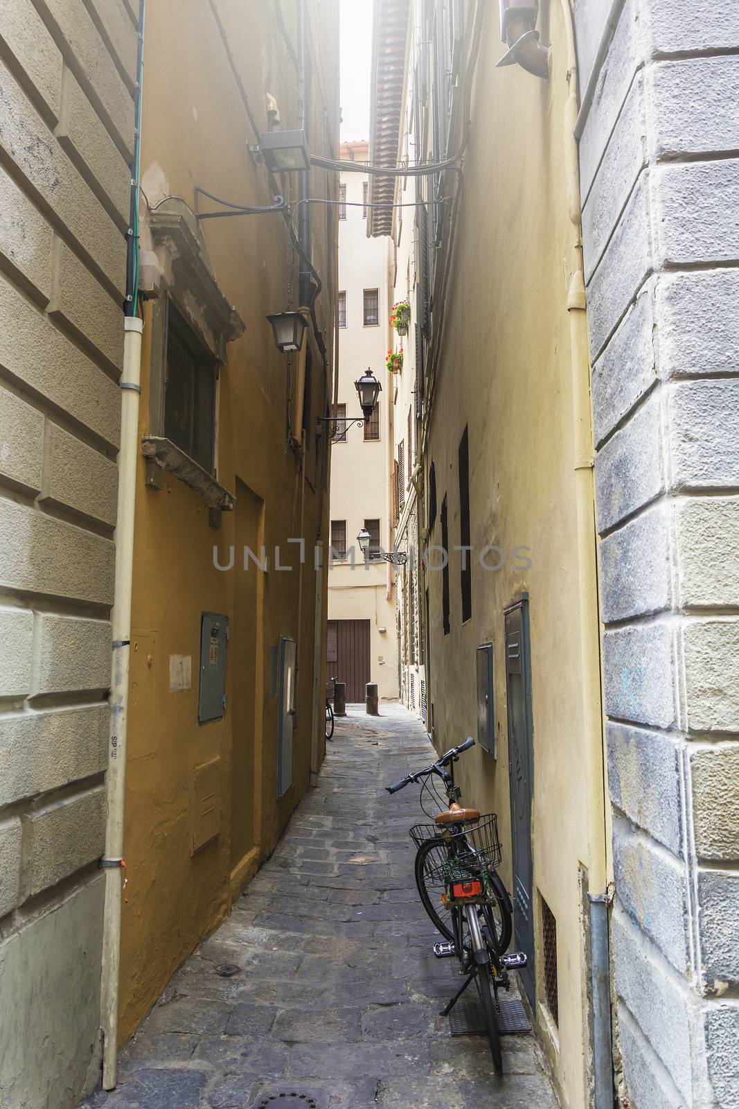 view of a bicycle leaned on a wall of a narrow alley in Florence, Italy