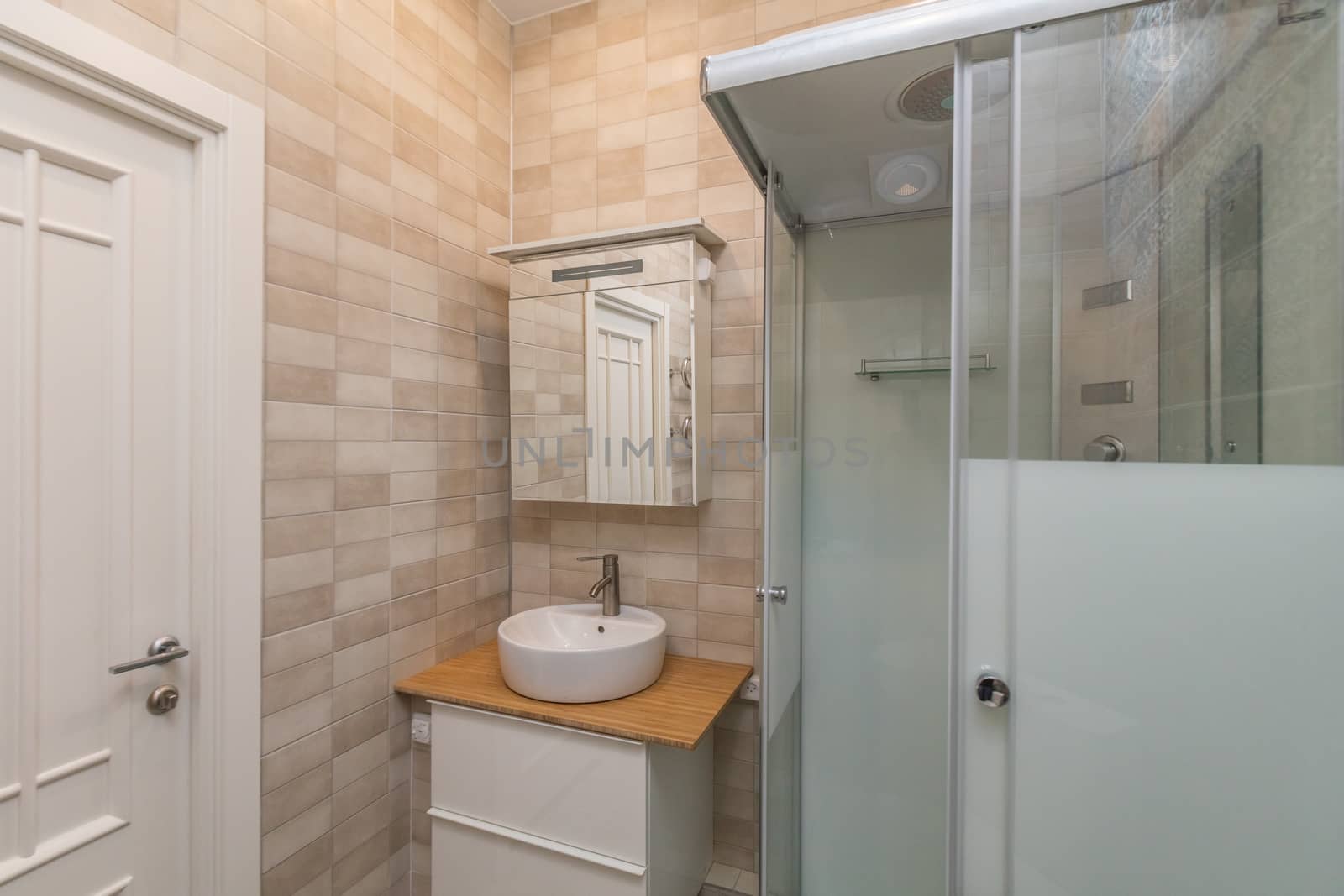 Small beige tile bathroom with Shower cabin and sink