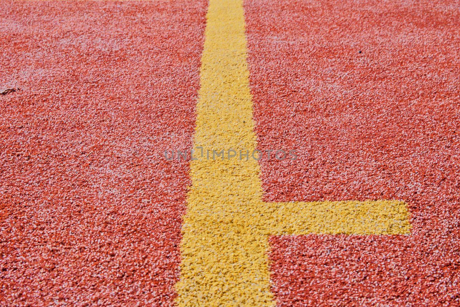 Yellow line on red playing field. Copy space. Sport texture and background by roman_nerud