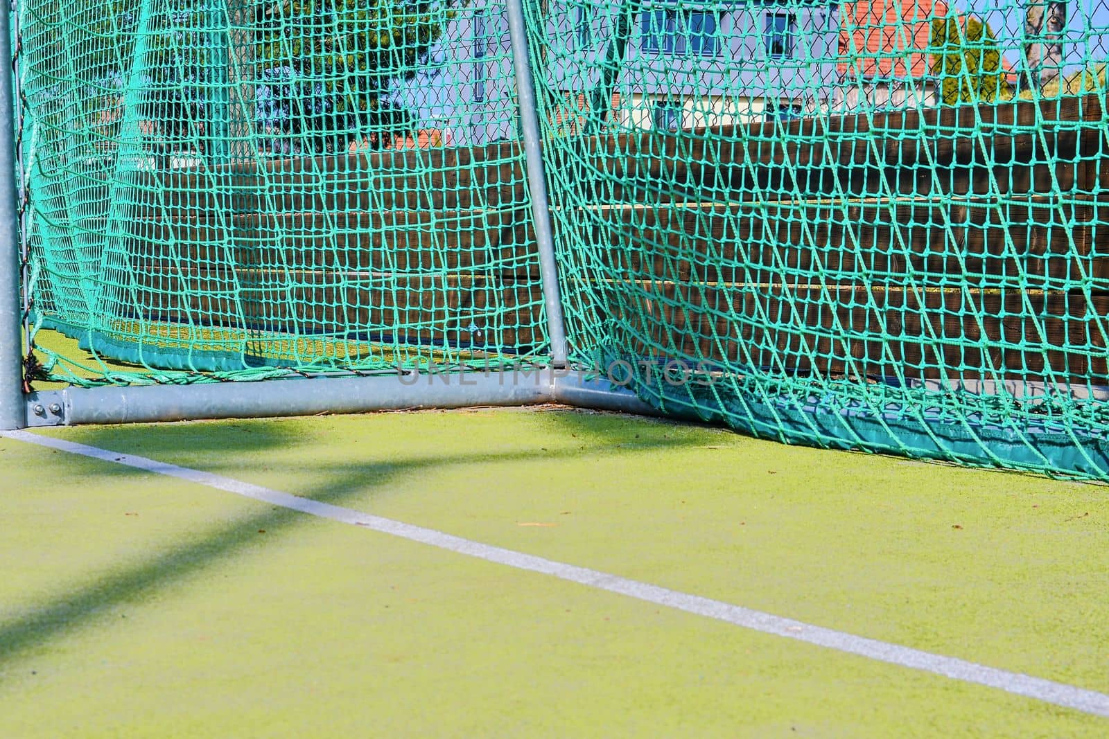 Goal with net and green playing field. Closeup. Sport texture and background. 