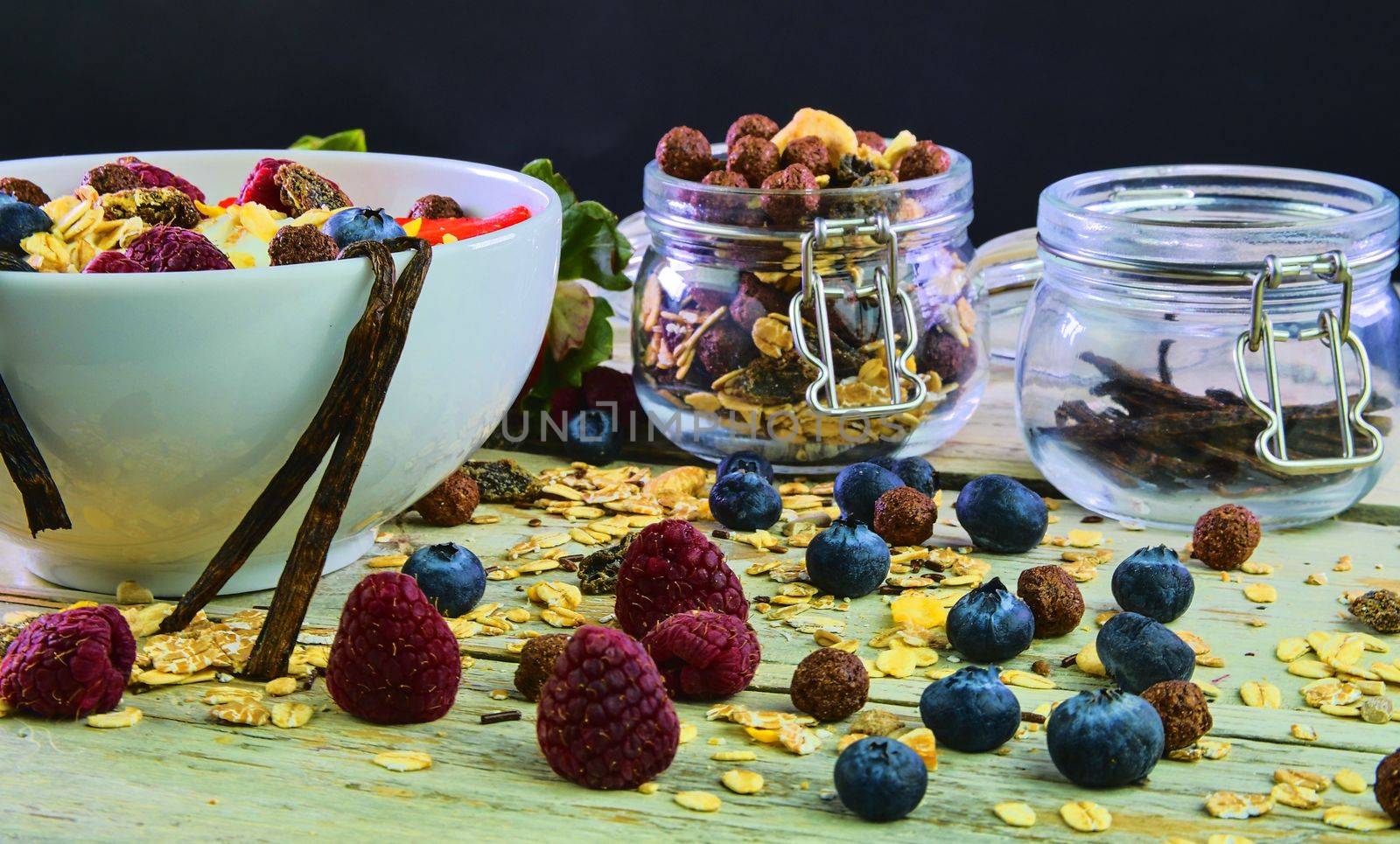 Healthy breakfast, cereal with yoghurt, strawberries, blueberries, raspberries and muesli on wooden rustic background.  Concept of: fitness, diet, wellness and breakfasts by roman_nerud