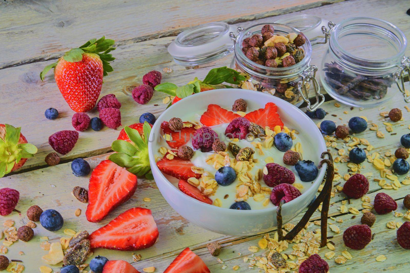 Composition of a typical genuine breakfast made with yogurt, blueberries, raspberries, blackberries, muesli. Concept of: fitness, diet, wellness and breakfasts