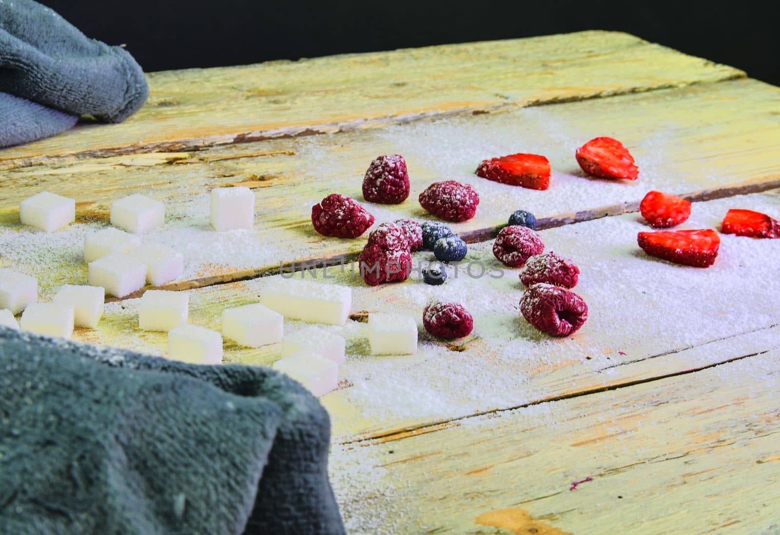 Cup of coffee, sugar cubes, blueberries and strawberries on wooden background. Winter or Valentines day concept.
