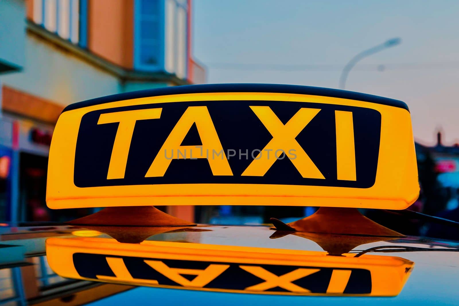 Lit taxi sign on roof of taxi car in the city by roman_nerud