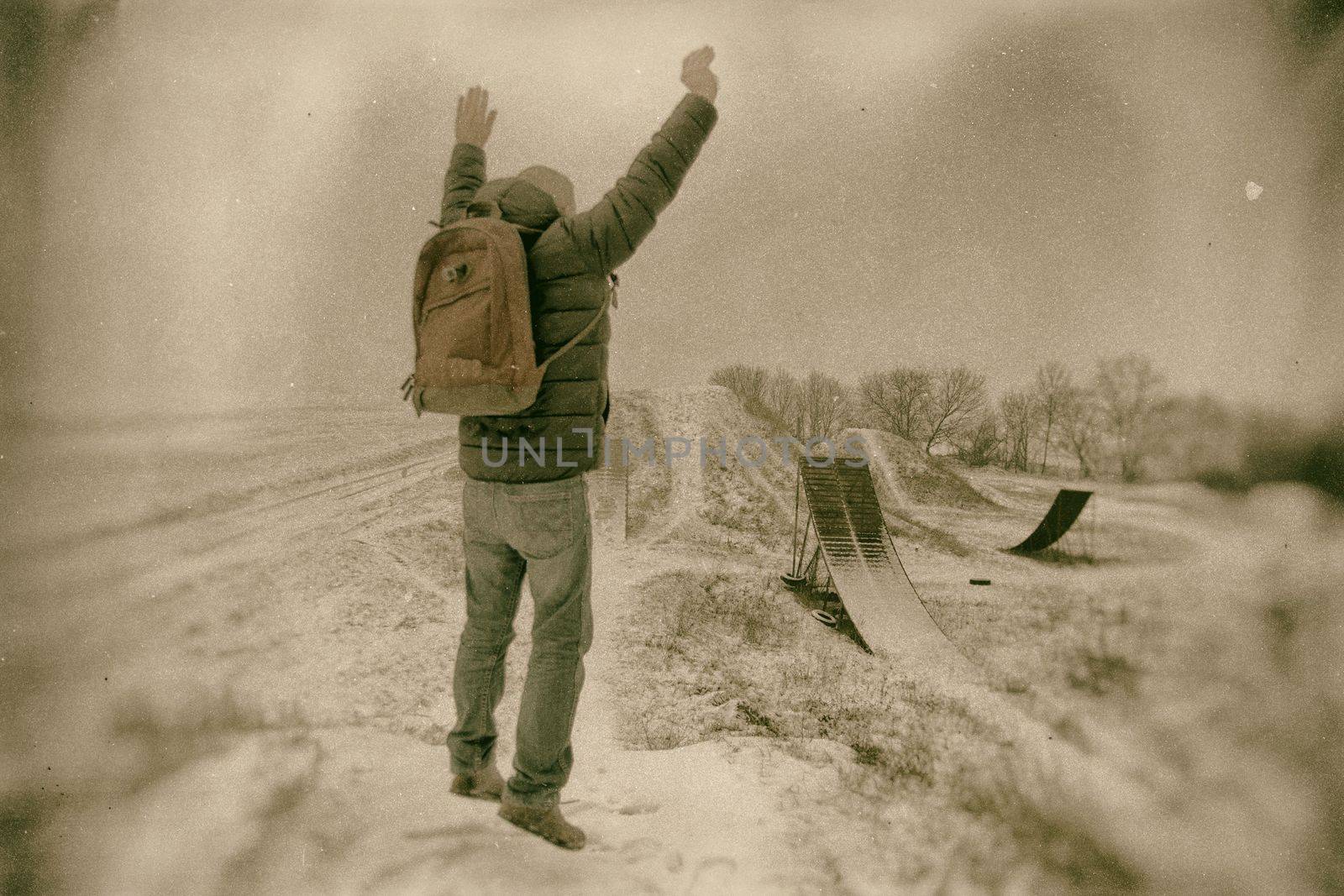 Middle age man jumping  in beautiful winter landscape . Man viewing on abandoned freestyle motocross ramps. Add color and oher filters. by roman_nerud