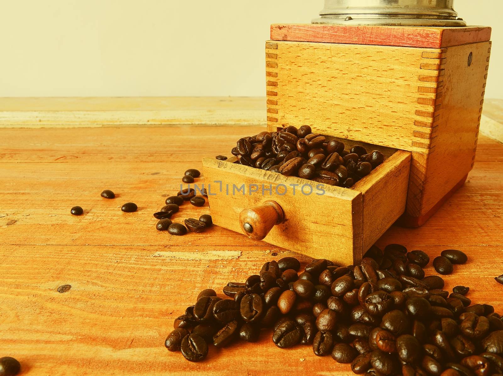 Vintage coffee mill and coffee beans on wooden background. 
