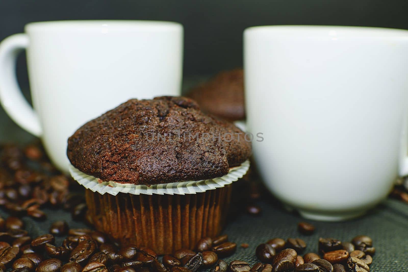 Dark muffins, cups of coffee and coffee beans on black background.  by roman_nerud